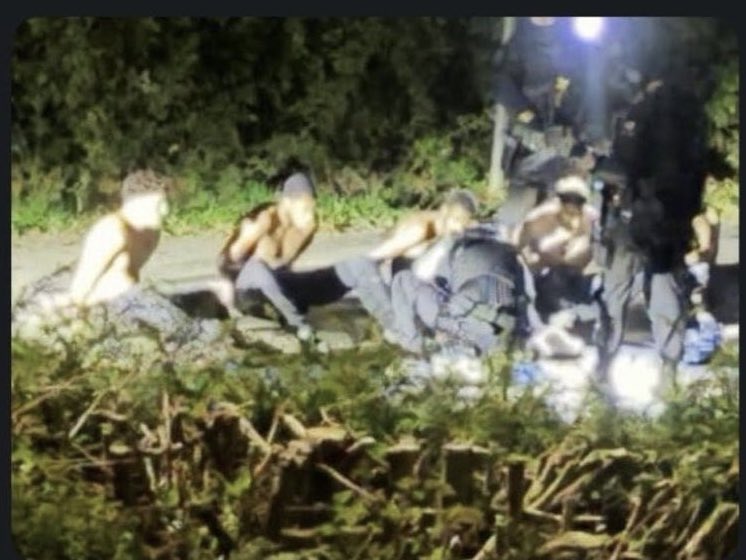JamesBrian29916's tweet photo. 🚨 This photo was apparently captured at 3am this morning on Whelford road which runs adjacent to RAF Fairford

I can’t verify as Its been passed by someone else but it appears to show 5 dark skinned men under arrest with at least 3 armed police officers on site.

If what appears to have happened is true then Shabana Mahmood needs to step down immediately and a national security emergency called.