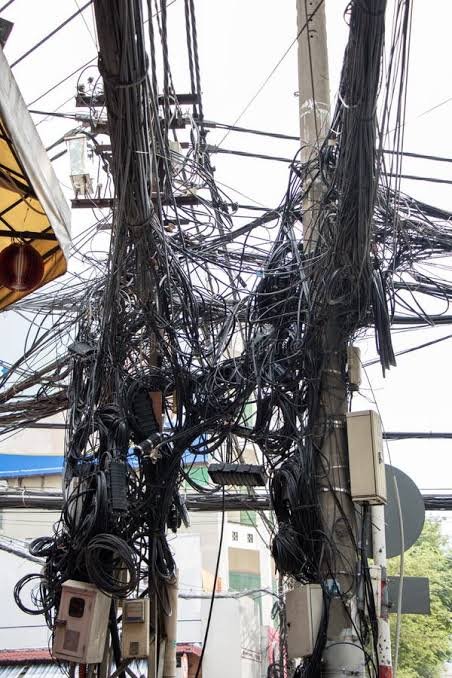 Lock85832854's tweet photo. @njaanabhi The top 4 chunky cables are the ones carrying electricity.

When you see a Electricity pole that looks like it has pubic hair is because  ISPs technicians are very filthy and unorganized. https://t.co/8FrB8ijg08