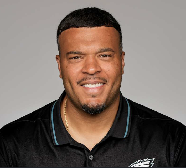 DavidNeiszPHL's tweet photo. Philadelphia Eagles Run game coordinator and tight ends coach Ryan Mahaffey, the forgotten man

Mahaffey is a first-time NFL run game coordinator. His coaching journey, while unconventional in some ways, suggests he can evolve the Eagles' rushing into one of the league's best.
A former fullback at Northern Iowa, Mahaffey briefly played for the Baltimore Ravens, Indianapolis Colts, and Miami Dolphins after entering the NFL as an undrafted free agent in 2011. His playing career was short, but it gave him firsthand experience with the physical demands and details required to succeed in a run-first offense.
His coaching career has been more extensive. Mahaffey has coached at Northern Iowa as a TE coach, then served as a graduate assistant for Notre Dame for two years before returning to Northern Iowa as co-offensive coordinator and wide receivers coach. He then went to Western Kentucky to coach tight ends again. Back to Northern Iowa as their OC before heading to the NFL as Green Bay's offensive quality control coach.
Ryan spent five seasons under head coach Matt LaFleur learning the offense from all aspects. Rather than remaining in a single role, but rather coached across multiple positional groups. He shifted to assistant offensive line coach for two seasons, then two more as the Packers’ wide receiver coach before becoming Philadelphia’s run game coordinator and tight ends coach.
The Eagles are banking on that extensive experience paying off, along with Mahaffey's full understanding of the running game to elevate their rushing attack.
Successful rushing concepts are not built solely by talented running backs or dominant offensive linemen. Receivers have to block downfield, tight ends have to seal the edge, quarterbacks have to make the right decisions, and offensive linemen have to communicate seamlessly before and after the snap. Many moving parts and assignments must work in concert to succeed.
Mahaffey has coached offensive linemen, receivers, and tight ends. He has seen each piece of that puzzle up close. His job is to make sure everyone not only understands their job, but executes it properly. It will not be a finished product in the first part of the season, but it will keep evolving.
For Eagles fans, one area to watch is continued creativity. Philadelphia has long relied on a powerful offensive line that can win at the point of attack, but modern NFL rushing offenses increasingly use motion, misdirection, formation variation, and changing blocking angles to create favorable matchups.
Mahaffey’s time in Green Bay exposed him to one of the league’s more creative offensive systems, one that blended zone concepts, play-action, and pre-snap movement to keep defenses guessing.
His background as a former assistant offensive line coach also suggests an emphasis on fundamentals. Footwork, leverage, and communication up front will remain critical. Every detail matters to their success.
Mahaffey’s dual role as run game coordinator and tight ends coach could also increase the importance of the tight end position in Philadelphia’s offense. Johnny Mundt has started the year strong and demonstrated how vital his role will be this year.
Bringing in a new run game coordinator to add wrinkles and change the run-game scheme, with more outside-zone concepts, is Mahaffey’s responsibility. His role is to ensure the technique, timing, and communication match Mannion’s vision.