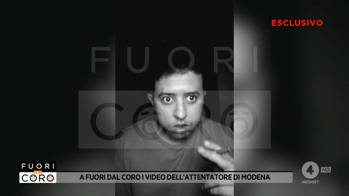 A black-and-white news broadcast screenshot from Mediaset 'FUORI DAL CORO' channel 4, labeled 'ESCLUSIVO' in red, showing a man with the Italian text 'A FUORI DAL CORO I VIDEO DELL'ATTENTATORE DI MODENA'.