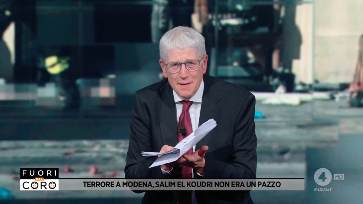 A silver-haired man in a dark suit, burgundy tie, and glasses gestures while holding papers on the Italian news program "Fuori dal Coro" on Canale 4 (HD). The lower-third text reads "TERRORE A MODENA, SALIM EL KOUDRI NON ERA UN PAZZO," matching the broadcast's discussion about the Modena attacker.