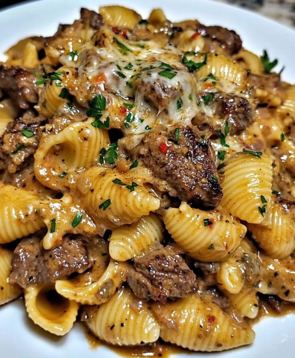 LabMariam48488's tweet photo. Creamy Beef and Shells

Yield: 4–6 portions
Prep Time: 15 minutes
Cooking Time: 25 minutes
Total Time: 40 minutes
Difficulty: Easy

Ingredients

Ingredient| Quantity
Beef sirloin, cut into 2 cm cubes| 450 g
Olive oil| 15 ml
Onion, finely diced| 100 g
Garlic, minced| 10 g
Tomato paste| 30 g
Italian seasoning| 3 g
Garlic powder| 3 g
Onion powder| 2 g
Paprika| 2 g
Red pepper flakes| 0.5–1 g
Salt| 5 g, or to taste
Black pepper| 1 g
Beef stock| 480 ml
Medium pasta shells| 225 g
Heavy cream| 120 ml
Sharp cheddar cheese, grated| 150 g
Fresh parsley, chopped| 15 g

Method

1. Prepare and sear the beef
Pat the beef dry and season lightly with salt and black pepper. Heat the olive oil in a large, heavy-based skillet over medium-high heat. Add the beef in a single layer and sear for 2–3 minutes per side until well browned. Avoid overcrowding the pan. Remove the beef and set aside.

2. Build the sauce base
Reduce the heat to medium. Add the diced onion to the same pan and cook for 3–4 minutes until softened. Add the garlic and cook for 30 seconds.

Add the tomato paste, Italian seasoning, garlic powder, onion powder, paprika and red pepper flakes. Cook for 1 minute, stirring continuously.

3. Cook the pasta
Pour in the beef stock and stir to release the browned fond from the bottom of the pan. Add the pasta shells and bring to a gentle simmer.

Cover and cook for 8–12 minutes, stirring occasionally, until the shells are tender and most of the liquid has been absorbed. Add a small amount of water or stock if necessary.

4. Finish the dish
Reduce the heat to low. Return the seared beef to the pan and stir in the cream. Simmer gently for 1–2 minutes.

Remove from the heat and gradually stir in 120 g of the grated cheddar until melted and the sauce is smooth and creamy.

Taste and adjust seasoning.

5. Garnish and serve
Sprinkle the remaining 30 g cheddar over the top and allow it to melt. Garnish with chopped parsley.

Serve immediately.

Standardization Notes

- Beef: Sirloin provides tender, defined pieces. For a more economical version, use another suitable braising/steak cut and adjust cooking time.
- Pasta: Medium shells are preferred because they capture the creamy sauce.
- Sauce consistency: The finished sauce should be creamy and coat the pasta without being excessively thick.
- Cheese: Grate cheese immediately before use for better melting.
- Food safety: Cook beef to the applicable safe internal temperature for the intended doneness/service standard. For food-business production, maintain appropriate hot-holding and service controls.
- Service: Best served immediately while the sauce is smooth and the cheese is melted.
#MariamFoodLab