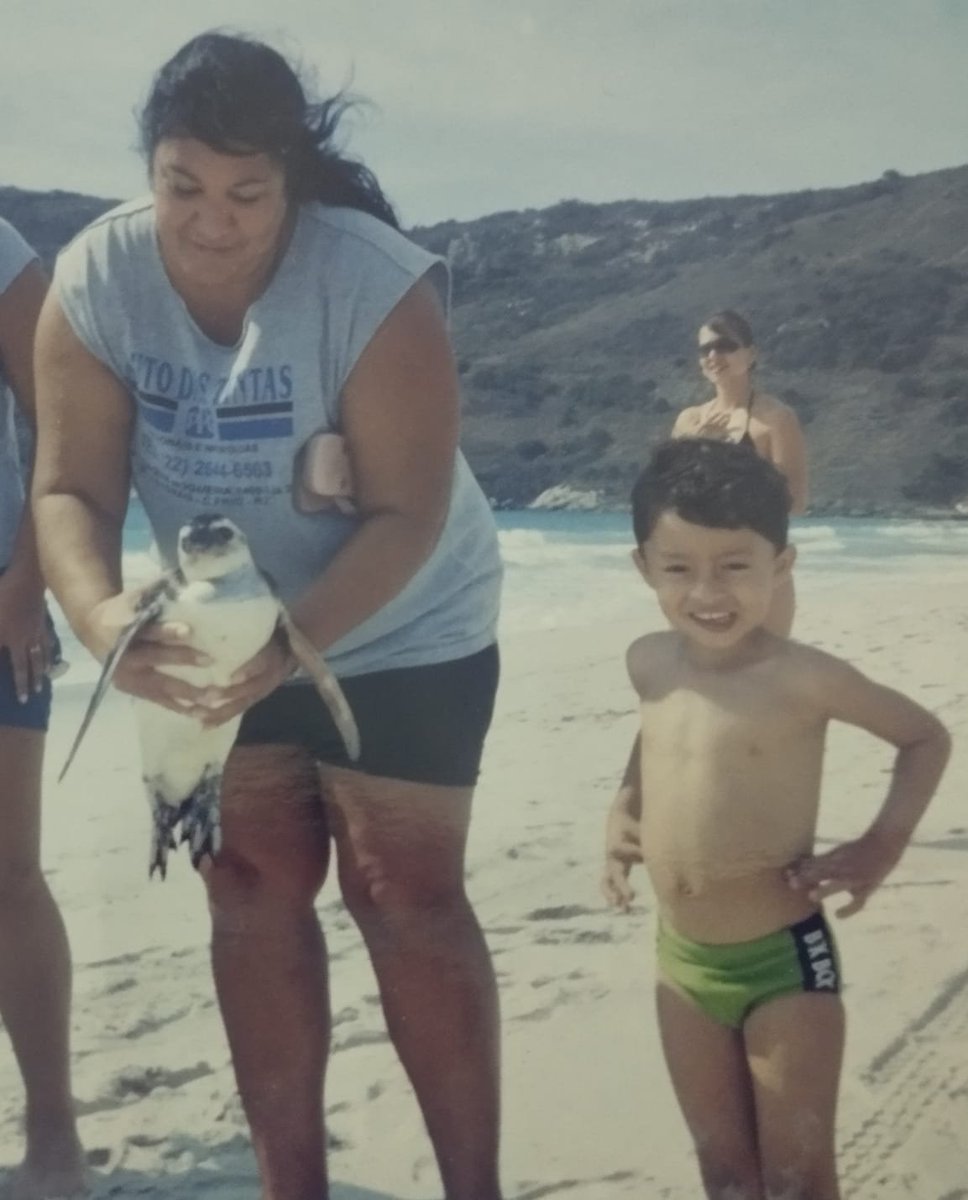 gabpereiraaaa's tweet photo. Minha mãe tirou essa foto minha com um pinguim resgatado. Hoje eu trabalho resgatando eles na praia que frequentei a minha infância inteira https://t.co/0xcjGhWq5L
