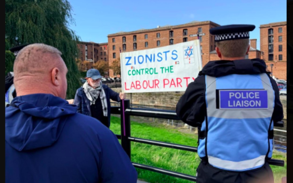 trishaposner's tweet photo. The hard-left didn’t get their “genocide” motion or full arms embargo onto the Labour Party conference agenda.
So now they’re standing outside in Liverpool with the ludicrous, “ZIONISTS CONTROL THE LABOUR PARTY.”

When the “pro-Palestine” zealots don' get their way they turn immediately to show their world view: Jews are the puppet-masters. It would be laughable if it weren’t so familiar.