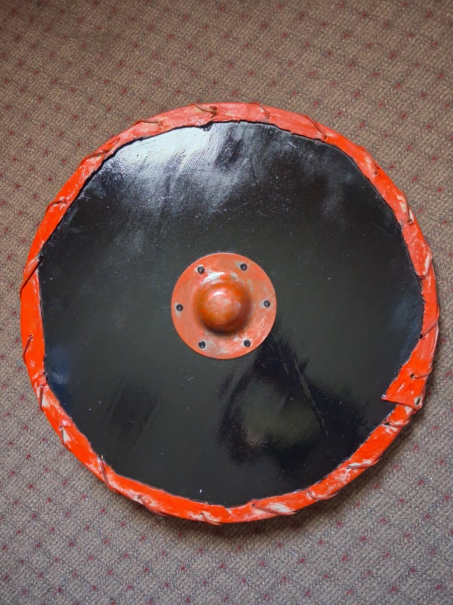 VolkNewsDotC0m's tweet photo. This Viking shield has hung on my print shop wall for years looking hideous. Finally got around to painting it. Wood, steel, leather, canvas, and a rim of soaked pet-store dog bones bent around the edge. Might add to the design later — for now it's done. https://t.co/BHNFDUhYPd