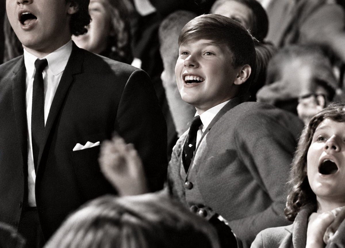 Hot_Pepper76's tweet photo. In 1964, a 13-year-old student at London's Barbara Speake Stage School was hired as an extra for the Beatles' first movie, A Hard Day's Night.

He was sent to the Scala Theatre and placed in the audience while the Beatles filmed their concert sequence.

His job was simple: be one of the screaming young Beatles fans.

When the movie came out, he looked for himself but couldn't find the footage.

Thirty years later, producer Walter Shenson gave him the unused film from that day. He went through it until he finally found his 13-year-old self in the audience.

The performance was "You Can't Do That," which had been cut from the finished film.

The kid in the middle of this photo went on to have quite a music career of his own.

That 13-year-old was Phil Collins.