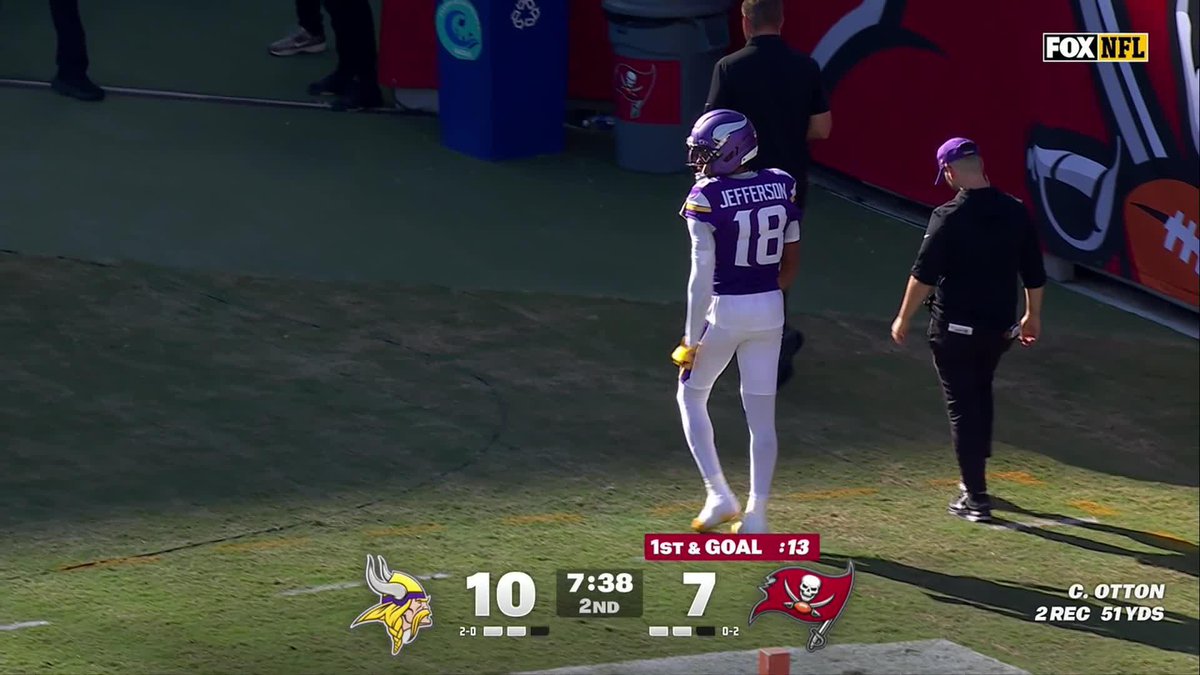 An NFL game broadcast screenshot showing Minnesota Vikings player Jefferson (#18) on the sideline, with the scoreboard indicating Vikings 10, Buccaneers 7, 7:38 left in the 2nd quarter, 1st & Goal.