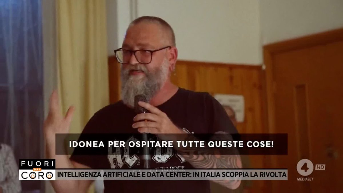 A man with a beard and glasses speaks into a microphone on the Italian TV show 'Fuori dal Coro' (Mediaset Channel 4), with the subtitle 'INTELLIGENZA ARTIFICIALE E DATA CENTER: IN ITALIA SCOPPIA LA RIVOLTA' and on-screen text reading 'IDONEA PER OSPITARE TUTTE QUESTE COSE!'.