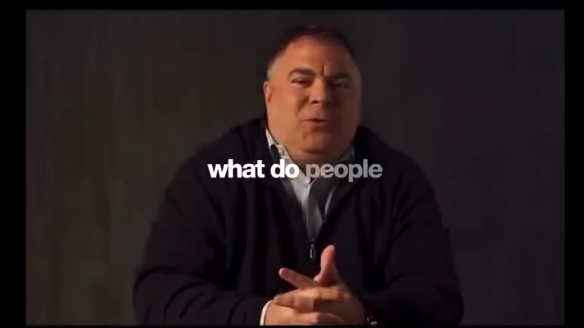 A man in a dark sweater speaks directly to the camera against a dark background, with the subtitle 'what do people' visible.