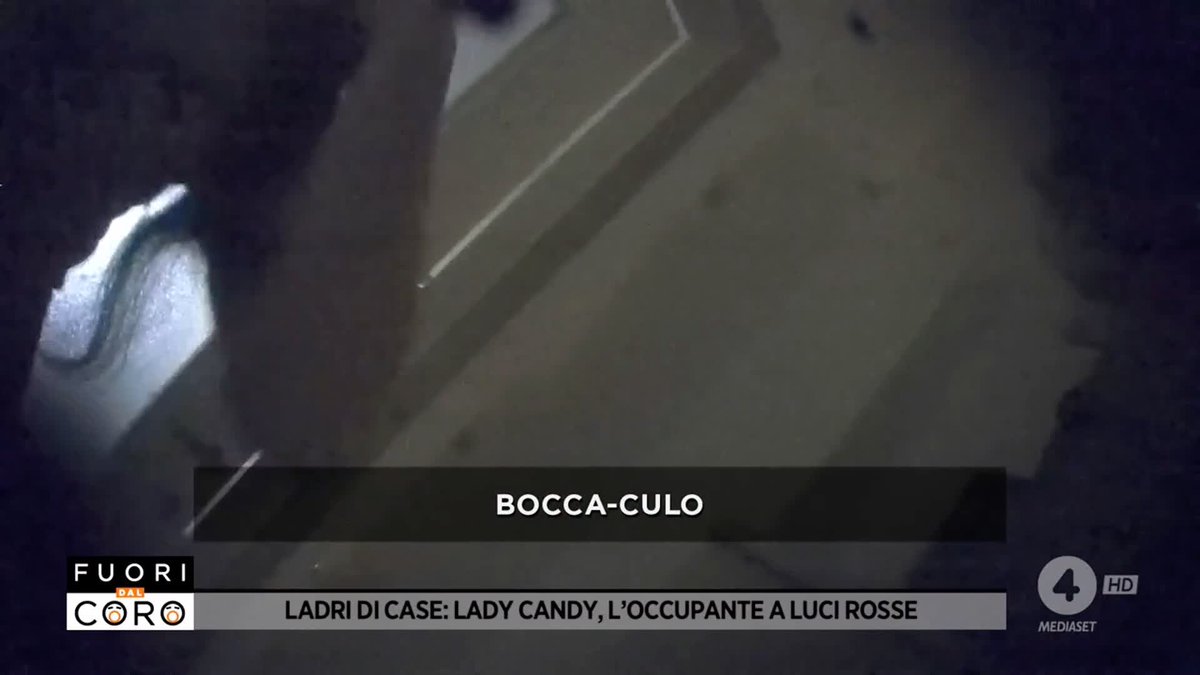 A blurry surveillance camera shot shows a person at a door with the caption 'BOCCA-CULO' and a banner reading 'LADRI DI CASE: LADY CANDY, L'OCCUPANTE A LUCI ROSSE' from the show 'Fuori dal Coro' on Canale 4 HD Mediaset.