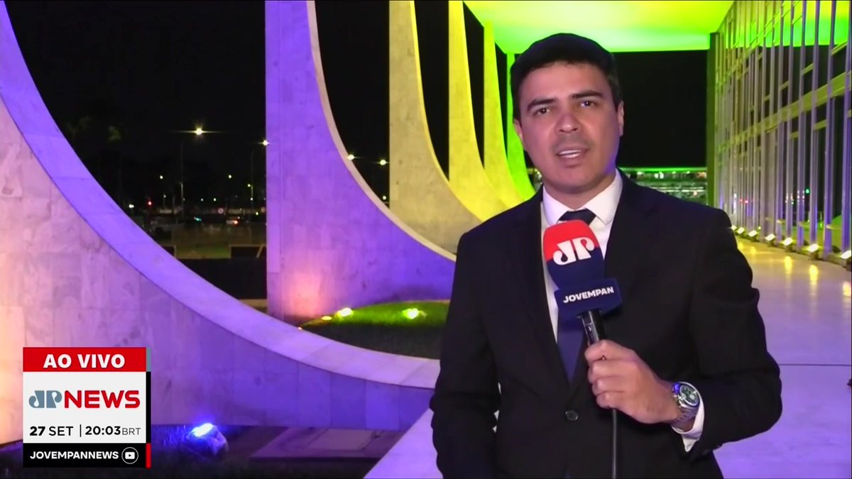 A JP News reporter delivers a live nighttime report from an illuminated modern building, with on-screen graphics reading "AO VIVO," "27 SET | 20:03 BRT," and "JOVEMPANNEWS," corresponding to the breaking news segment on tensions at the STF involving new evidence and messages from Daniel Vorcaro with Alcolumbre.