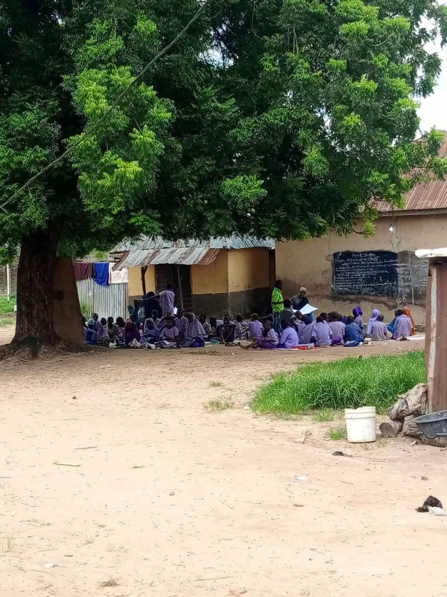 monitng's tweet photo. BUSTED!!!

Attn Governor @HonBago 

How can children in Niger State still be learning under a tree in 2026?

At Madaki Primary School in Gbaiko Bosso Estate, Minna, pupils are reportedly learning under a tree, sitting on bare ground, with a blackboard fixed to a dilapidated wall. Even more worrying, the school is reportedly only about 6 kilometres from the Niger State Government House.

This is happening in the state capital, not in a remote community.

It raises serious questions about the government’s priority for public education, especially at a time when Niger State has received over ₦48.3 billion in FAAC allocations.

The wider picture is also troubling. Niger State has one of the highest rates of children out of school in Nigeria, with widely cited NBS data putting the rate for children aged 6–15 at 42.8%. Local officials have also previously cited more than 700,000 out-of-school children in the state.

So what is being done to ensure that children who are already in school have a safe and decent place to learn?

@NigerStateGovt and @NigerStateSUBEB should urgently visit Madaki Primary School and other schools facing similar conditions. Parents and residents deserve to know when these schools will be fixed and what concrete steps are being taken.

Education should be treated as a priority, not an afterthought.

No child should be forced to sit on bare ground under a tree simply because government has failed to provide a basic classroom.

The people of Niger State deserve accountability, transparency and urgent action.

If education is truly a priority, when will these children get a classroom?

#FixPublicSchools