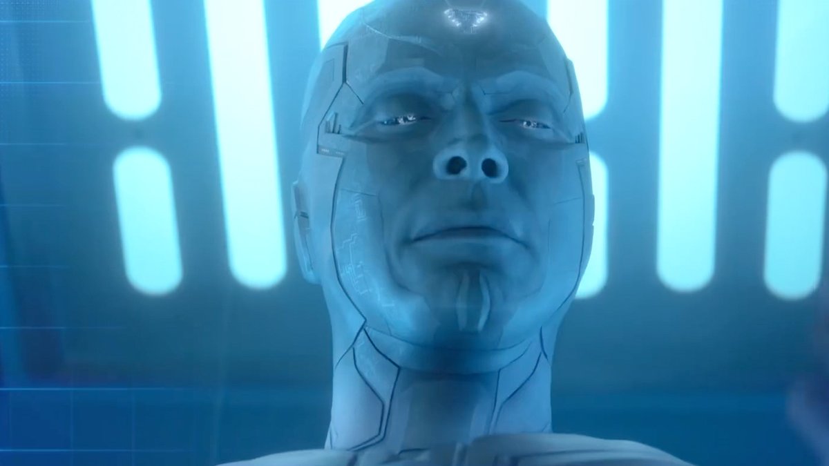 A close-up of a pale, humanoid android or robot with intricate facial features, set against a backdrop of glowing blue vertical lights.