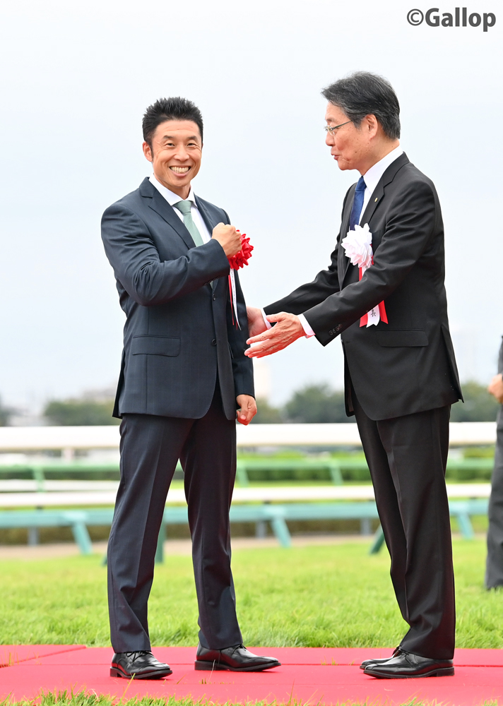 gallop_keiba's tweet photo. プレゼンターとして紹介されるも、登壇せずに「パワー！」をしてしまい、理事長に登壇を促される #なかやまきんに君 https://t.co/EahNtgPdFh