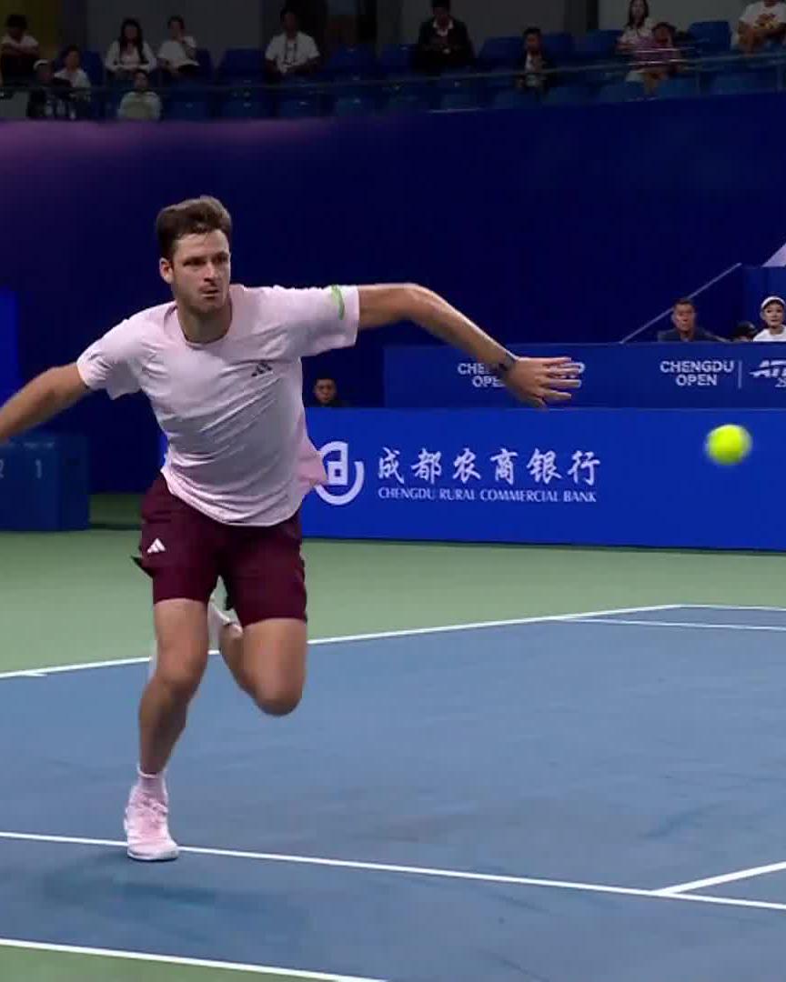 Hubert Hurkacz lunges to return a forehand during a match at the Chengdu Open, as advertised on the backdrop alongside Chengdu Rural Commercial Bank sponsorship signage. The action shot captures the athleticism that helped him secure the sensational point over Denis Shapovalov en route to the semifinal.
