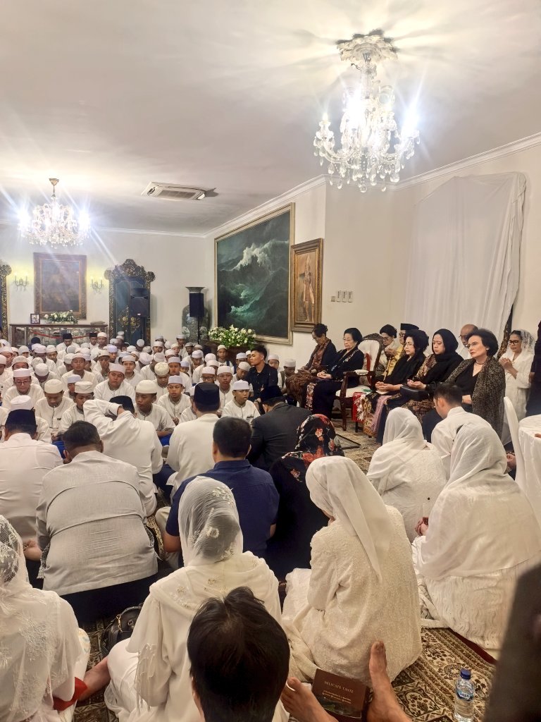 GunRomli's tweet photo. Ibu Megawati Bersama Keluarga Besar Bung Karno Khusyuk Doakan Almarhum Guruh Soekarnoputra di Tahlilan Hari Ketiga

250 Anak Yatim Ikut Tahlilan Hari Ketiga Guruh Soekarnoputra, Ibu Megawati dan Puan Hadir

JAKARTA — Tahlilan hari ketiga wafatnya seniman Guruh Soekarnoputra digelar di kediamannya di Jalan Sriwijaya, Jakarta, Senin (28/9/2026) malam. Kakak kandung Guruh yang juga Ketua Umum PDI Perjuangan, Megawati Soekarnoputri, hadir bersama keluarga besar Presiden pertama RI Soekarno.

Turut hadir Ketua DPR RI yang juga keponakan Guruh, Puan Maharani, serta M. Rizki Pratama. Tampak pula Puti Guntur Soekarno dan Romy Soekarno bersama anggota keluarga besar Bung Karno lainnya.

Guruh Soekarnoputra meninggal dunia pada Sabtu (26/9/2026). Kepergian putra bungsu Presiden pertama RI Soekarno dan Fatmawati tersebut meninggalkan duka mendalam bagi keluarga besar Bung Karno serta dunia seni dan kebudayaan Indonesia.

Dalam acara tersebut, Ibu Megawati duduk bersama adiknya, Sukmawati Soekarnoputri. Di dekat mereka tampak Puan Maharani dan istri Guntur Soekarnoputra, Henny Emilia Handayani.

Duta Besar Republik Tunisia untuk Indonesia, Mohamed Trabelsi, juga hadir dalam tahlilan tersebut. Ia terlihat duduk tidak jauh dari Ibu Megawati.

Suasana khusyuk terasa ketika pembacaan ayat-ayat suci Al-Qur'an dan doa untuk almarhum Guruh dimulai. Sekitar 250 anak yatim turut mengikuti rangkaian tahlilan dengan tertib dan khidmat.

Ibu Megawati terlihat tekun mengikuti pembacaan Surah Yasin, tahlil, serta Surah Al-Fatihah bersama para jemaah yang hadir.

Seniman senior Indro juga tampak hadir dan khusyuk mengikuti doa untuk Guruh.

Ketua Panitia Tahlilan Guruh Soekarnoputra, Puti Guntur, mengatakan seluruh rangkaian tahlilan hari ketiga berjalan lancar.

"Alhamdulillah tahlilan hari ketiga berjalan dengan lancar. Tadi pembacaan Yasin oleh Ustadz Abdul Razak, Tahlil oleh Ustadz Taufik Syamsudin dan doa oleh Ustadz Syabhani," kata Puti di Jalan Sriwijaya, Jakarta, Senin (28/9/2026) malam.

Selepas doa bersama, Ibu Megawati tampak menakupkan kedua tangannya sebagai salam penghormatan kepada pemandu acara tahlilan.

Tahlilan tersebut menjadi momen keluarga besar Bung Karno bersama para kerabat, sahabat, seniman, dan ratusan anak yatim untuk mendoakan Guruh Soekarnoputra pada hari ketiga kepergiannya.

Foto: Monang Sinaga & Guntur Romli