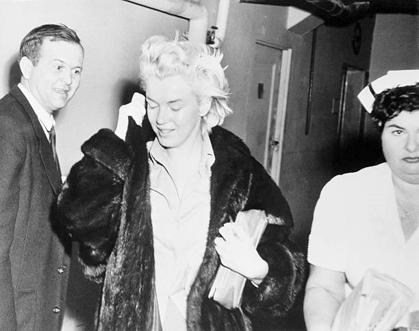 PetronellaWyatt's tweet photo. Marilyn Monroe leaving Columbia Presbyterian Hospital in New City on March 6, 1961. It was one of the most harrowing and traumatic experiences of her life. By February of that year, Marilyn was concerned about her addiction to prescription drugs, and was suffering from clinical depression following her divorce from Arthur Miller. Her New York psychoanalyst, Dr. Marianne Kris, suggested she check into a hospital for a "rest cure". Instead, Monroe was admitted to the Payne Whitney Psychiatric Clinic under a high-security classification. Upon arrival, her clothes and belongings were confiscated and she was placed in a barred and padded cell used for severely disturbed and violent patients. The actress was subjected to constant surveillance and denied her liberty.  Being so confined traumatised Monroe, whose greatest fear was inheriting the mental illness that had institutionalised her mother and grandmother. She later described her experience in a letter to her other psychiatrist, Dr. Ralph Greenson, writing that it felt like "a prison for a crime I hadn't committed." After four days of isolation, Monroe was finally granted access to a telephone and called her ex-husband, Joe DiMaggio. DiMaggio hurried to the clinic and demanded her release, reportedly threatening to tear the hospital apart "brick by brick.” Marilyn was discharged from Payne Whitney on February 17, and  transferred to Columbia Presbyterian Hospital, where she was given a private room and therapeutic support until her departure in March.