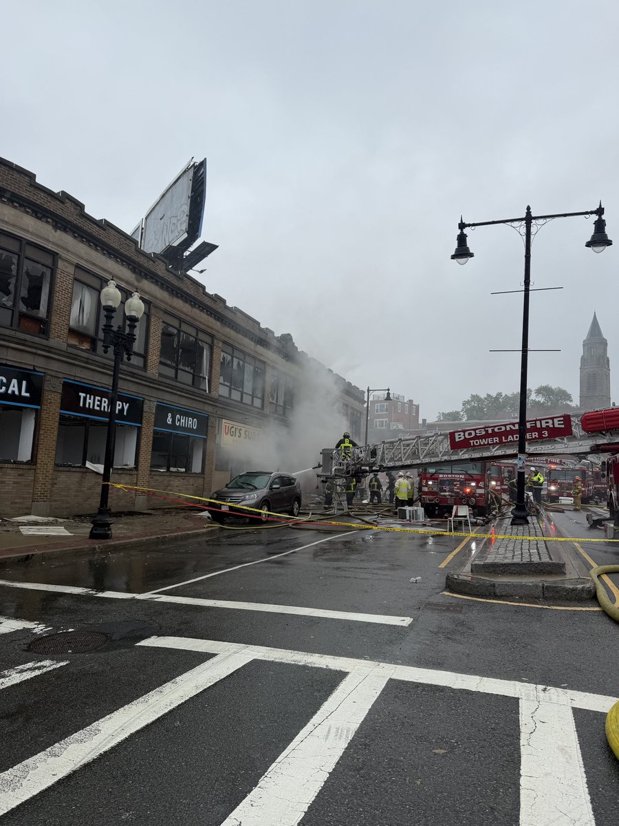 BostonFire's tweet photo. Fire companies have started to rotate out &amp; get rehabbed. Traffic is still impassable due to large feeder lines that run from hydrant to engines. The fire has been knocked down to being just in the basement level which continues to push out significant dark smoke. https://t.co/3kjo3yDgOo