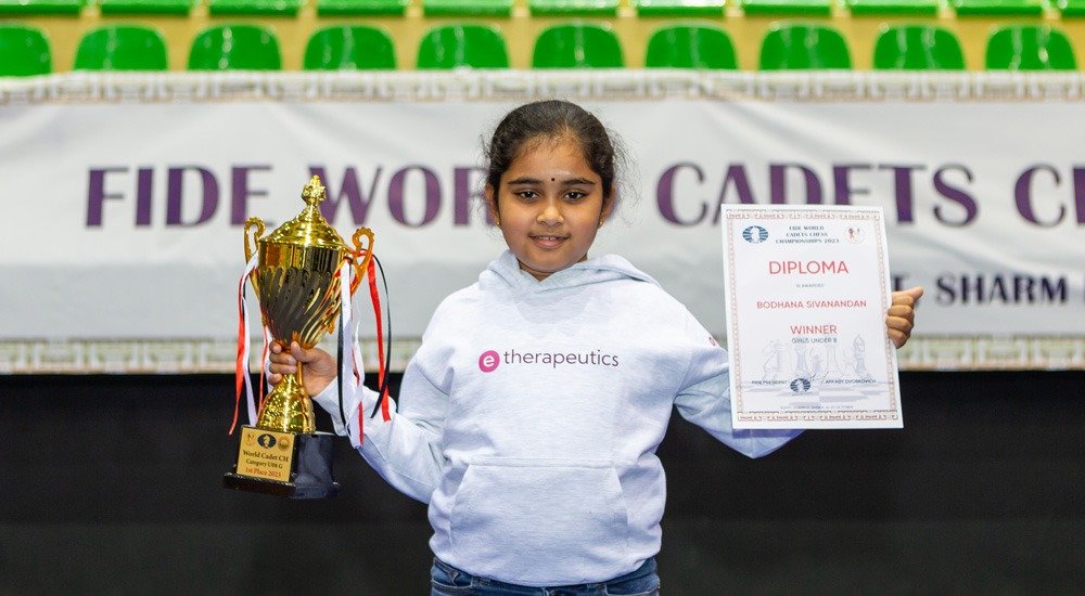 TamilGuardian's tweet photo. 🚨 British Tamil Bodhana Sivanandan becomes youngest woman grandmaster in chess history

The British Tamil schoolgirl from Harrow secured her third and final norm playing all 11 rounds on England's top board at the Chess Olympiad in Samarkand, finishing on eight points. The record had stood since Kateryna Lagno and Hou Yifan took the title at 12.

"I'm happy to do it, but I want to keep going and keep making history as well, instead of just stopping here," she told FIDE.

She learned the game at five, during lockdown, from a chessboard given to her by a family friend leaving for India. At seven she won all 24 games at the European Schools Championship. At nine she became the youngest person ever to represent England internationally in any sport. At ten she became the youngest female player to beat a grandmaster.

She is now two norms into the open international master title, and says she wants the grandmaster title next.