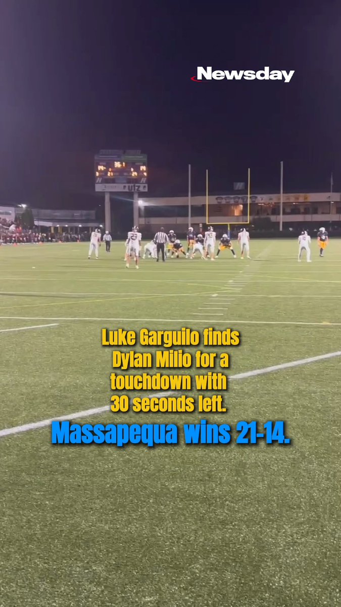 A Newsday video screenshot of a nighttime football game with the caption: 'Luke Garguilo finds Dylan Milio for a touchdown with 30 seconds left. Massapequa wins 21-14.'