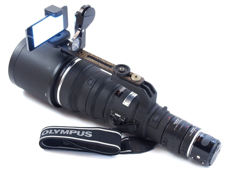 ASUS_ZenBlog's tweet photo. OLYMPUS AIRといえばこの記事。換算1200mmの超望遠を肩に担ぐスタイルで、シャッターとファインダーはWi-Fi接続したiPhoneで行う。レンズ後端に付いたちっちゃい塊がカメラ本体にはとても見えない。 https://t.co/lOfYmU2Kuk