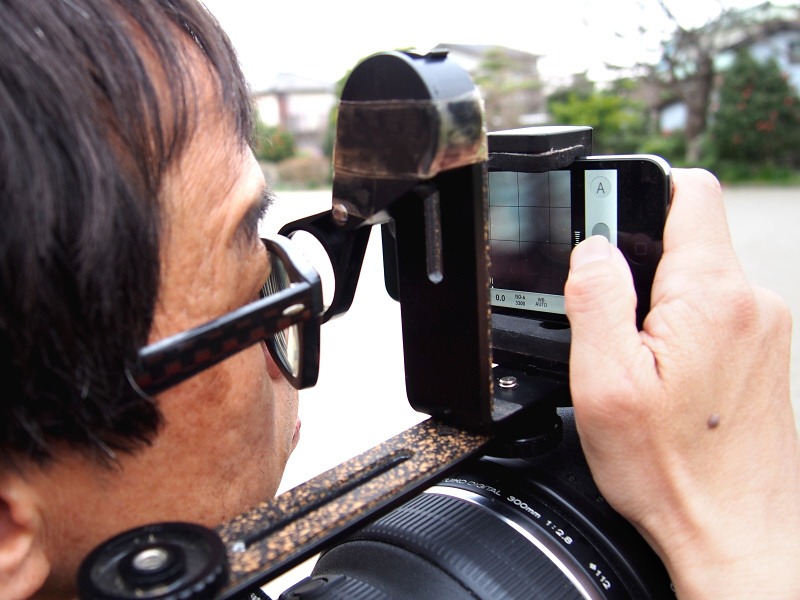 ASUS_ZenBlog's tweet photo. OLYMPUS AIRといえばこの記事。換算1200mmの超望遠を肩に担ぐスタイルで、シャッターとファインダーはWi-Fi接続したiPhoneで行う。レンズ後端に付いたちっちゃい塊がカメラ本体にはとても見えない。 https://t.co/lOfYmU2Kuk