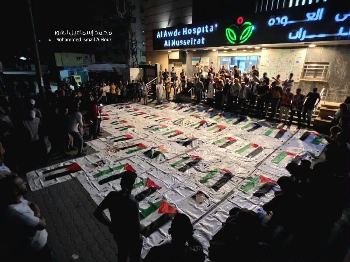 HaithamElmasri1's tweet photo. Shrouds are being prepared for human remains recovered from beneath the rubble of Al-Muhandisin Tower, east of Nuseirat in central Gaza, in preparation for their burial tomorrow.

Israel has turned the entirety of Gaza into a mass grave. https://t.co/0Q5geYKE2o