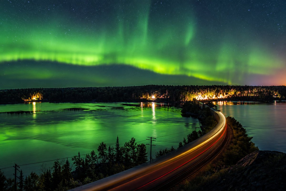JohnTavaresJr's tweet photo. Throwback: September 27, 2014. A view of Aurora Borealis, or Northern Lights, over Pelican Lake and West Point Cove, from a lower section of Sioux Mountain, while a freight train passes over Iron Bridge, in Sioux Lookout, Ontario, Canada. https://t.co/UPXVmJkioL