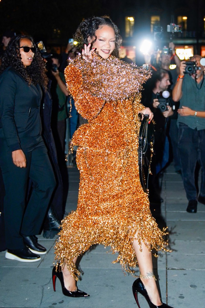 JustJared's tweet photo. Rihanna is going for gold! The star stepped out in a dramatic gold skirt suit during Paris Fashion Week, pairing the look with black heels and a matching bag. 

#Rihanna #ParisFashionWeek 
Photos: Backgrid https://t.co/DbDnTqZdPo