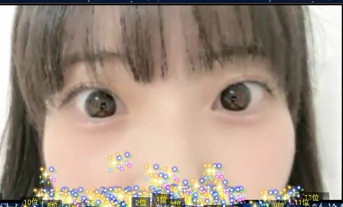 A close-up of a person's face with large eyes, partially obscured by a colorful sparkle filter at the bottom showing numbers like '10位', '9位', '2位', and '13位'.