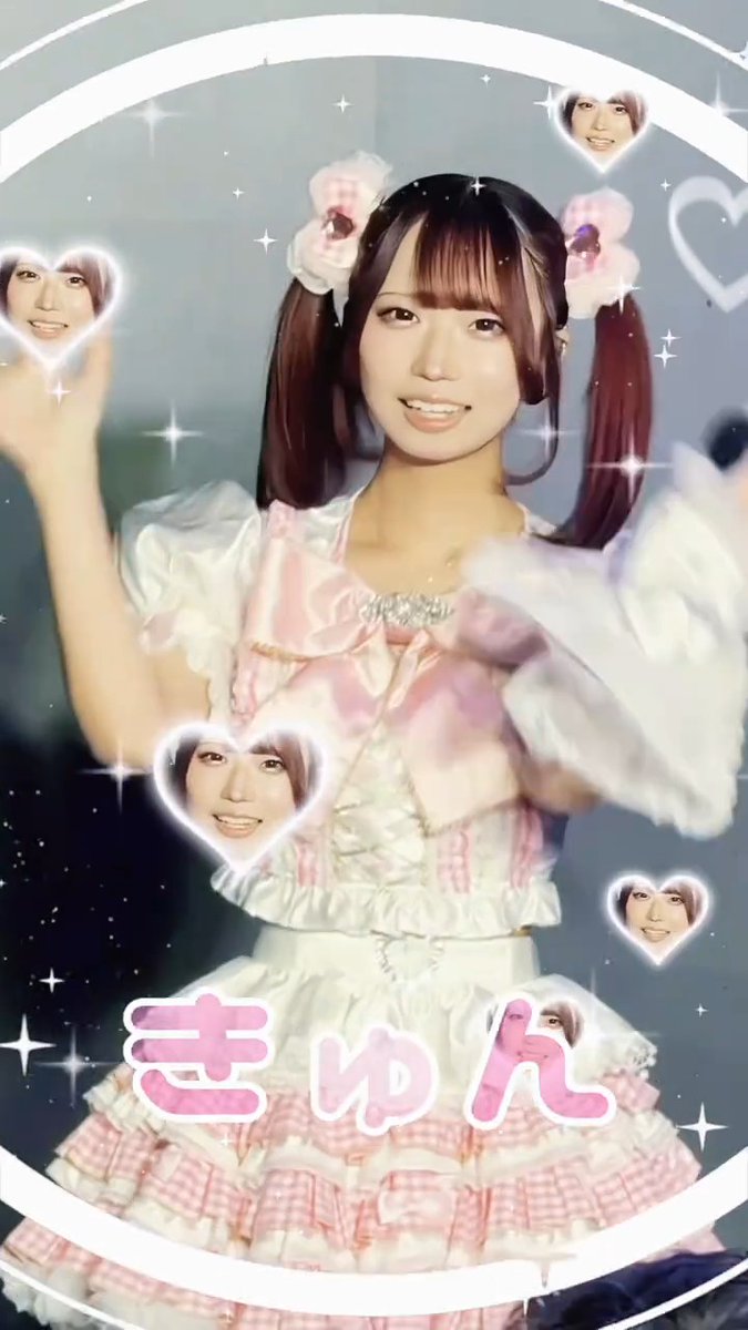 An image of a smiling woman in a pink and white frilly dress with pigtails, surrounded by floating heart graphics containing her face and the text 'きゅん'.