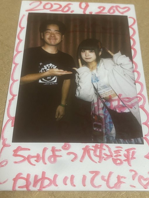 A Polaroid photo dated '2026.9.20' showing a man and a young woman posing together, with handwritten Japanese text at the bottom.