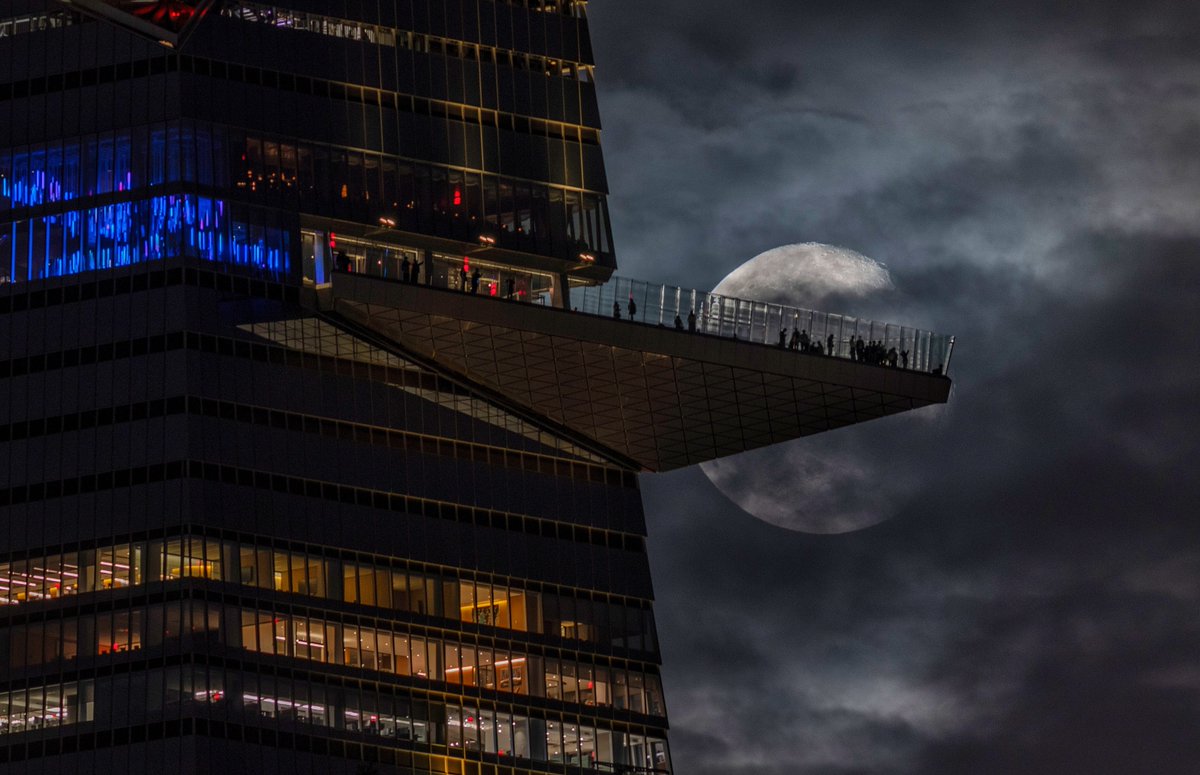 GaryHershorn's tweet photo. A 93 percent illuminated waning gibbous moon rises behind the EdgeNYC observation deck at Hudson Yards two days after the full Harvest Moon in New York City, Monday evening #newyorkcity #nyc #newyork #moon @edgenyc https://t.co/hyCjlmkfJm