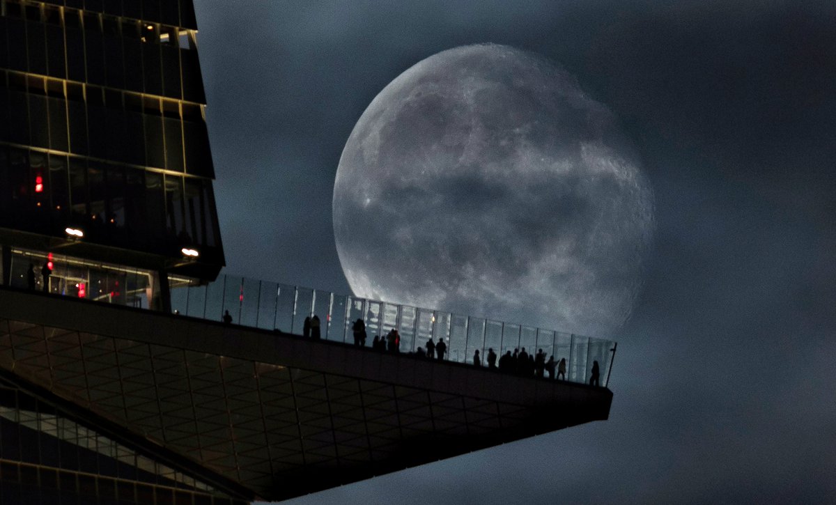 GaryHershorn's tweet photo. A 93 percent illuminated waning gibbous moon rises behind the EdgeNYC observation deck at Hudson Yards two days after the full Harvest Moon in New York City, Monday evening #newyorkcity #nyc #newyork #moon @edgenyc https://t.co/hyCjlmkfJm