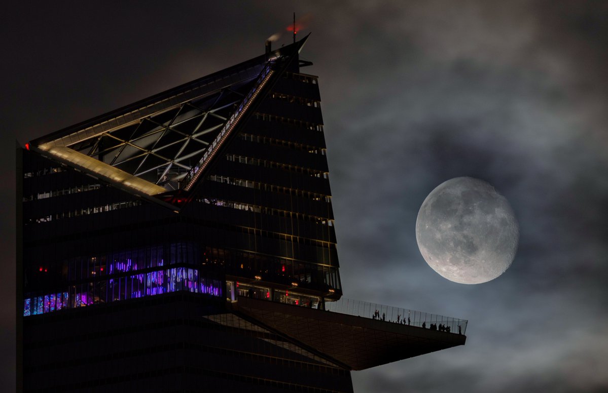 GaryHershorn's tweet photo. A 93 percent illuminated waning gibbous moon rises behind the EdgeNYC observation deck at Hudson Yards two days after the full Harvest Moon in New York City, Monday evening #newyorkcity #nyc #newyork #moon @edgenyc https://t.co/hyCjlmkfJm