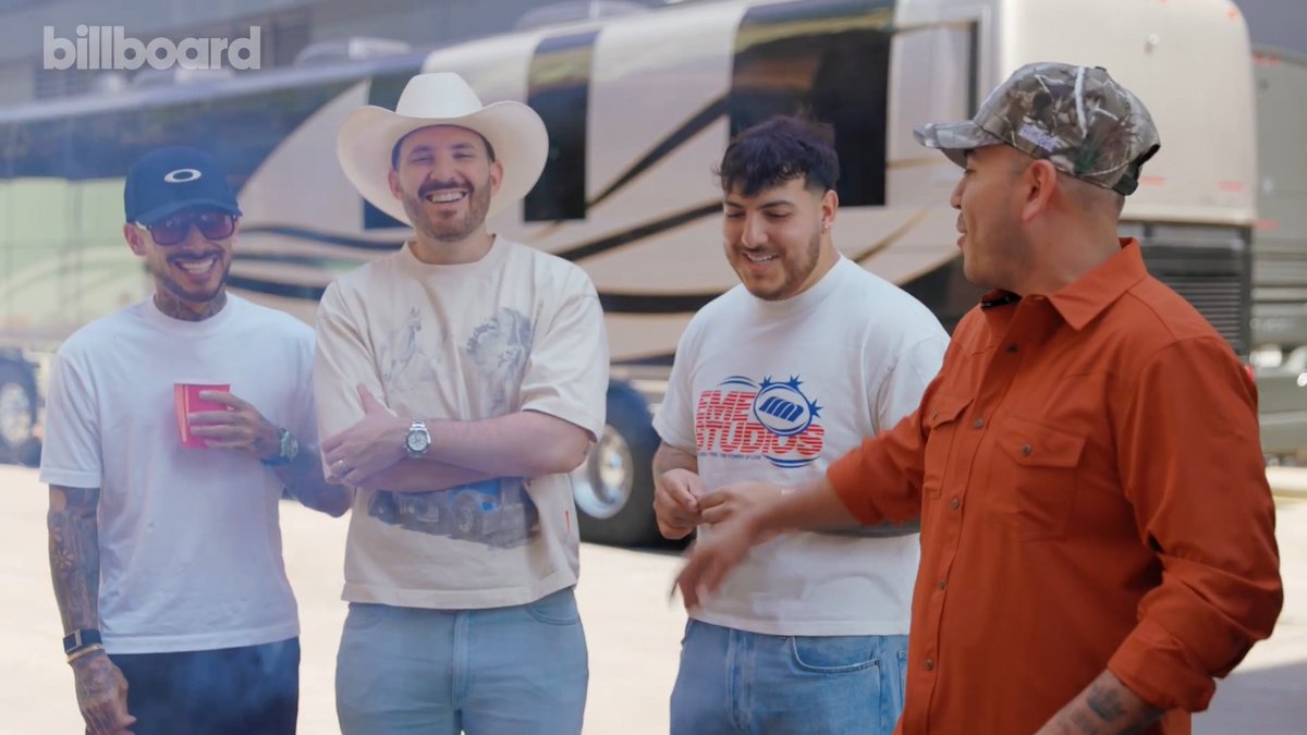 Four men stand smiling together in front of a tour bus with the Billboard logo in the upper left, including two members wearing a "FAME STUDIOS" t-shirt, one in a white cowboy hat, and another in an orange shirt and camouflage cap. The image accompanies a Billboard feature on Grupo Frontera, where the group discusses their favorite songs to play during cookouts.