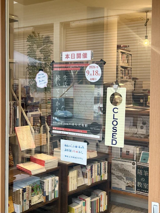 本棚や書籍が並ぶ店内をガラス越しに撮影した写真。「本日開催」やイベント案内のポスターが見える。