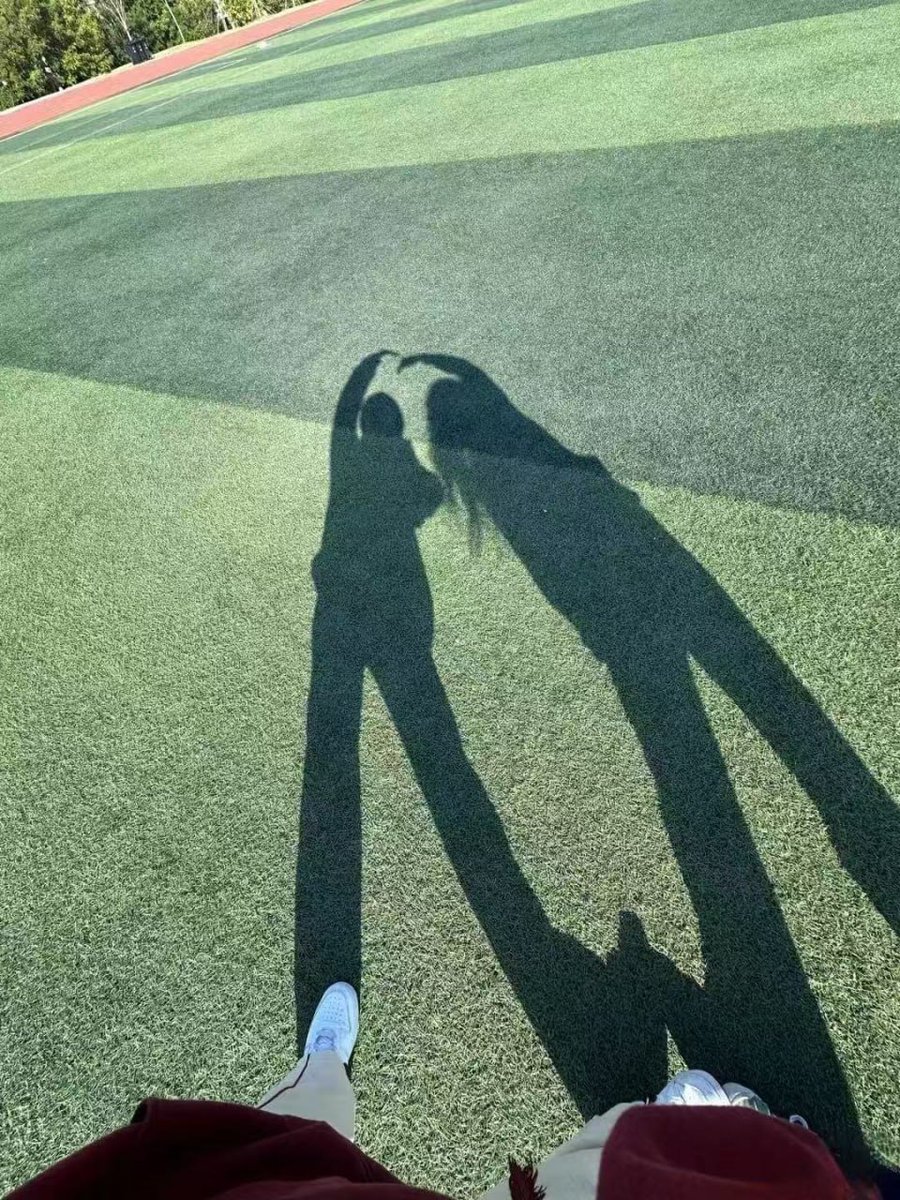 Daianaawan's tweet photo. Sometimes, the best view is the shadow of you and your friend, even creating a little heart shape on the big field 💚 Just beware, the shadow is taller than the real me! 😂 #ShadowArt #FriendTime #LittleJoys https://t.co/mWYSbFOnzk