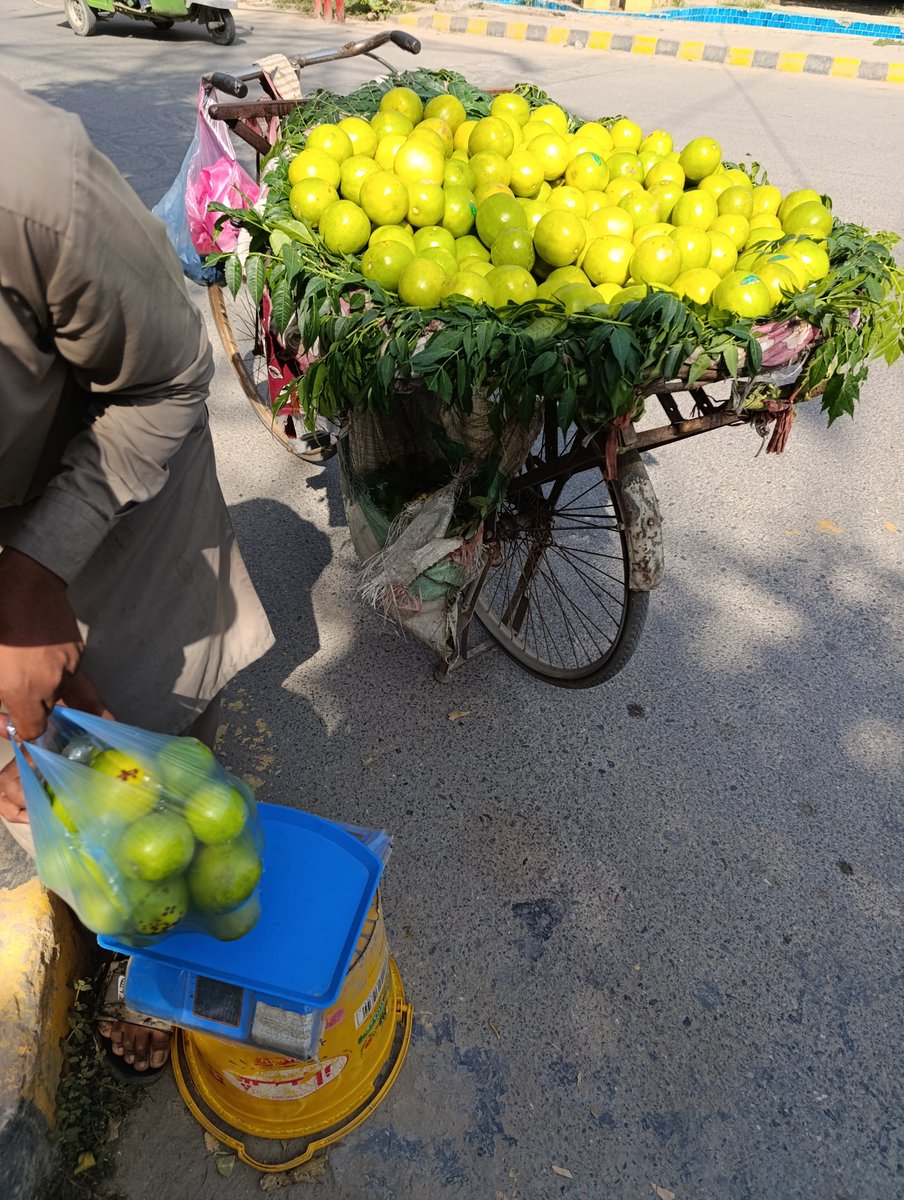 ImranMirMedia's tweet photo. سڑک پر یہ غریب نوجوان اپنی سائیکل تیزی سے لیے جارہا تھا۔ میں نے پھل لینا چاہا تو یہ نہیں رکا، صحافی کالونی گیٹ کی اندر والی سڑک پر میں نے اسے روکا تو دیکھا پیچھے کارپوریشن والے ٹرک لیے آرہے تھے۔ اس کی حالت دیکھی تو خستہ کپڑے، ٹوٹی پھوٹی سائیکل۔ بھاگنے کی وجہ پوچھی تو اس نے بتایا کہ کارپوریشن کے ہاتھوں دو دفعہ اپنا سامان لٹوا چکا ہوں۔ ہر چیز چھین کر لے جاتے ہیں۔ میں نے موبائل نکال کر ویڈیو بنانا چاہی تو کہنے لگا میربانی کریں نہ بنائیں کہیں لگا دی آپ نے تو یہ مجھے ڈھونڈتے پھریں گے اور نہ جانے کیا سلوک کریں۔
اس کے بعد میں نے اسے بتایا کہ تمہاری صرف سائیکل کی تصویر لگاؤں گا اور کہانی بھی کہ شائد ظالم حکمران اس غربت کا حل بھی بتا سکیں جو غریب دیہاڑی دار چل پھر کر دو وقت کی روزی کماتا ہے۔ یہ صرف ایک شخص کی کہانی نہیں ہر دیہاڑی دار مزدور روزانہ ایسی ہی صورتحال سے دوچار ہے۔