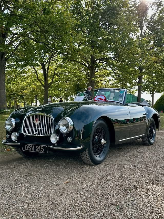 RestoMod804's tweet photo. Aston Martin DB1 Roadster—
Green full body color, chrome vertical-slat grille with red Aston Martin wing badge, chrome front bumpers, large round chrome headlights with small fog lights below. https://t.co/GjiuC0zKw7