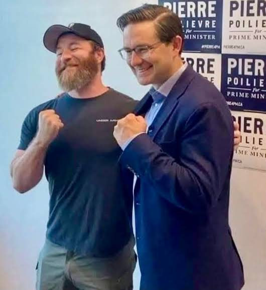 SeanCarleton's tweet photo. You know who was pretty quiet today regarding the masked white supremacists mobilizing in Kamloops with residential school denialism on the eve of the National Day for Truth and Reconciliation? @PierrePoilievre. Here he is posing with the group's founder. https://t.co/nVOWRmW6M6