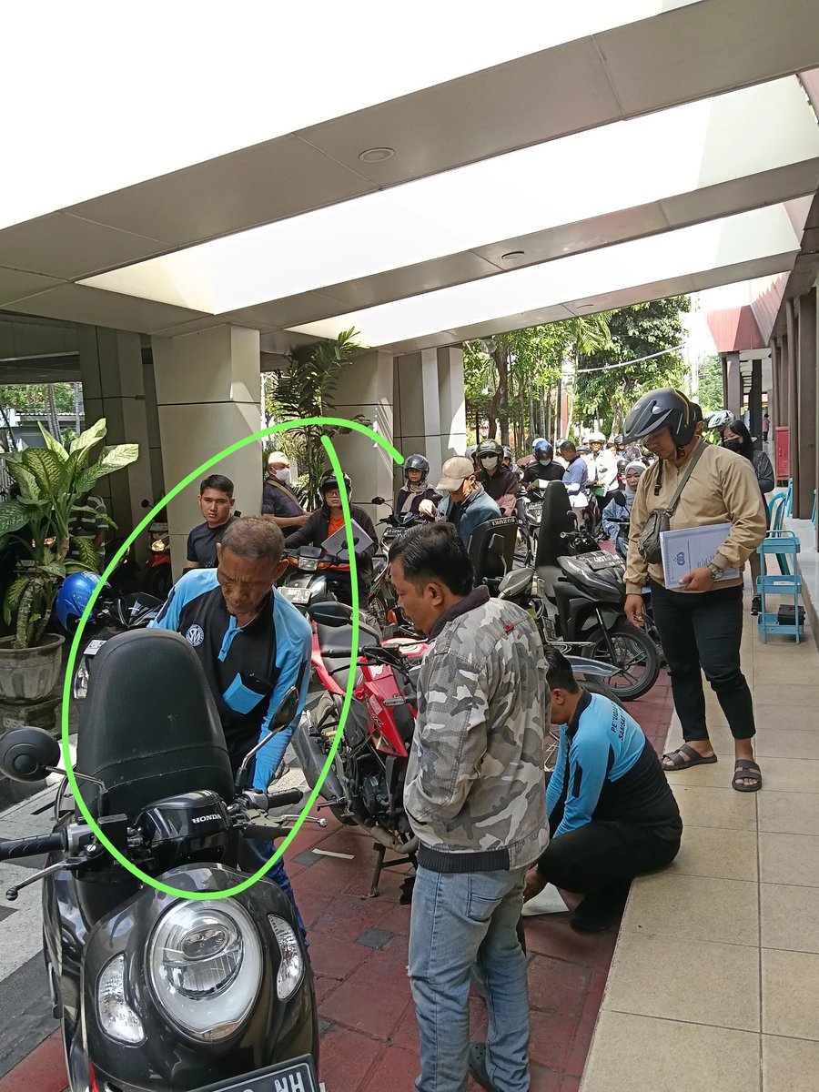 Smash1014314's tweet photo. Mari kita bahas dugaan pungli di Samsat Manyar Surabaya buat kalian yang mau perpanjang plat nomor 5 tahunan.

Kalau plat kendaraan kalian rusak atau bahkan tinggal secuil bagian besinya, mungkin sebaiknya dilengkapin dulu. 😭

Kronologinya begini.

Gue datang ke Samsat Manyar buat mutasi keluar sekaligus perpanjang plat. Kebetulan plat belakang gue hilang waktu berangkat kerja di Gresik. Semua surat-surat lengkap.

Pas antre cek fisik, awalnya aman-aman aja. Petugasnya juga melakukan gosok nomor rangka/mesin seperti biasa.

Setelah selesai, orang yang ngecek malah bilang,

“Seikhlase ae, Mas.”

Karena menurut gue itu termasuk pungutan, ya gue nggak kasih.

Pas gue mau pergi, tiba-tiba gue diteriaki, dicegat, terus plat kendaraan gue difoto.

“Plat belakang mana?”

Padahal dari awal dia sudah lihat kalau plat belakang gue memang nggak ada. Gue udah feeling bakal dipersulit gara-gara nggak ngasih uang tadi.

Gue jawab, “Hilang, Pak. Jatuh di jalan waktu berangkat kerja. Udah saya cari lagi tapi nggak ketemu.”

Dari situ gue makin ngerasa bakal ada masalah.

Gue juga sempat tanya ke petugas cek fisik, “Sebelum saya tadi ada orang yang platnya cuma separuh, nggak kelihatan L XXX. Itu bisa lolos, gimana, Pak?”

Dia cuma diem sambil foto kendaraan gue.

Setelah itu gue menuju loket. Sebelum masuk loket, kita diarahkan antre dulu ke dua security buat dicek kelengkapan surat.

Gue tanya ke security soal pungutan tadi.

Jawabannya,

“Emang seikhlasnya aja, Mas.”

Gue tanya lagi, “Kalau nggak dikasih gapapa kan, Pak?”

Dijawab, “Ya lihat aja nanti, Mas, diverifikasi.”

Akhirnya gue tunggu sampai nomor antrean gue dipanggil.

Di loket, surat gue dikasih catatan “plat belakang hilang”. Gue jelasin lagi kondisinya sekaligus nanya soal pungutan tadi.

Petugas loket cuma diem, lalu tanya ke temannya. Temannya malah nyuruh tanya ke loket verifikasi sebelumnya.

Intinya nggak ada yang mau jawab soal pungutan tadi. 😭

Mereka kemudian nyuruh gue ke tukang plat buat pasang plat belakang.

Gue jawab,

“Lah, mending saya ke tukang plat, pasang dua-duanya sekalian, nggak usah bayar pajak ginian.”

Mereka diem.

Gue mikir, buat apa gue harus ke tukang plat dulu, pasang plat lama, balik lagi ke Samsat buat dapet plat baru, terus pasang lagi? Ribet banget.

Gue tanya lagi,

“Memang ada aturannya, Pak? Kalau plat hilang, sudah dicari tapi nggak ketemu, harus bikin baru di tukang plat dulu supaya bisa perpanjang?”

Niat gue sebenarnya cuma mau tahu aturannya, bahkan kalau ada aturan tertulisnya gue mau foto supaya orang lain juga bisa ngerti sebelum datang ke Samsat.

Tapi mereka tetap kekeh nyuruh gue ke bagian verifikasi.

Karena udah kesel, akhirnya gue cabut semua berkas dari map, terus pergi sambil nguntel-nguntel formulir di dalam Samsat. 😭

Akhirnya gue pulang.