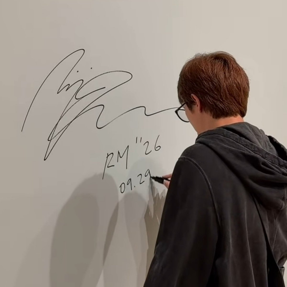 jwanbro's tweet photo. all those years of watching joon wander around museums js for him to one day be standing inside one signing the wall of an exhibition he curated . this means everything to me https://t.co/i0MQSSItvn