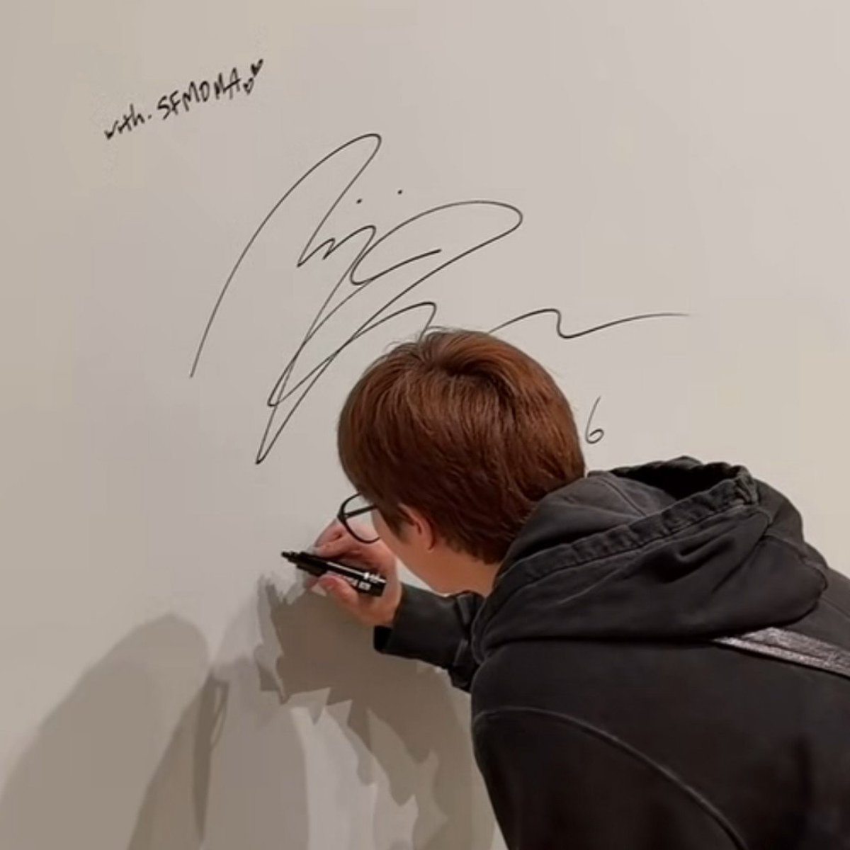 jwanbro's tweet photo. all those years of watching joon wander around museums js for him to one day be standing inside one signing the wall of an exhibition he curated . this means everything to me https://t.co/i0MQSSItvn
