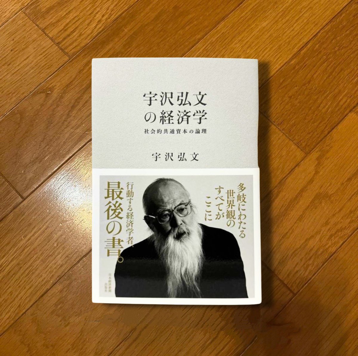 nobushiromasaki's tweet photo. 数学者・岡潔が「情緒」の有意義性を書いていたことを思い出した。本書は、経済学が数理的な要素だけでなく倫理も伴わないといけないということを教えてくれる。たとえば、水道料金の値上げがいまニュースになっている。全国の水道を維持するには平均で8割の値上げが必要だという試算もある。水道管の耐用年数が切れようとしているのに、人口が減って料金収入は先細ってきているのだ。この数字を前にして、ぼくらは二つのうちどちらかを選ぶことになる。「水道事業の採算が合わないなら料金を上げるか民営化する」か、あるいは「水道は採算で語るべきものではない」というロジックに行くか。

前者は経済の発想で、後者は倫理の発想のように思える。まさに「お気持ちの言葉」である。だが、宇沢弘文は、後者にも経済学の言葉性を見出す。本書は後者の言葉遣いに経済学的な骨格を与えようと試みる。

宇沢弘文は1928年に生まれ、2014年に亡くなった。ケネス・アローに認められて渡米し、36歳でシカゴ大学の教授になった。弟子にはのちにノーベル賞を受けるジョセフ・スティグリッツやジョージ・アカロフがいる。彼が示した二部門成長モデルや教育による人的資本の蓄積を組み込んだ成長モデルは、いまも経済学の教科書に載っている。しかも後者はロバート・ルーカスが1988年に発展させ、宇沢＝ルーカス・モデルとも呼ばれる。

端的に言えば、宇沢は市場原理を数学的に定式化する仕事の最前線にいたにもかかわらず、市場原理主義の批判者になった人物である。本書はその批判の集大成として読める。内容は三部構成で、第一部がリベラリズムの経済学と社会的共通資本、第二部が自動車の社会的費用と社会的共通資本、第三部が自然・都市・制度資本である。

社会的共通資本とは何か。宇沢の定義を要約すると、一つの国や地域が豊かな経済生活を営み、すぐれた文化を展開し、人間的に魅力のある社会を持続的に維持することを可能にする自然環境と社会的装置のことだ。具体的には三つの類型に分かれる。大気や水や森林といった自然環境、道路や水道や電力といった社会的インフラストラクチャー、そして教育や医療や金融や司法といった制度資本である。これらに共通するのは、私有財産として市場に委ねることも、国家が官僚的に管理することも、どちらも適さないという点だ。それぞれの分野の専門家が職業的な規範に従って管理することを宇沢は是とする。医師は医療を、教師は教育を、それぞれの職業倫理に基づいて運営し、市場の論理にも官僚の論理にも従わない状況を広げることを勧める。

個人的に興味深かったのは、地球温暖化に対して各国一律の炭素税ではなく、一人あたりの所得に比例した「比例的炭素税」と国際的な大気安定化基金を設けるべき、と提案していることだ。そして、学校教育と医療を社会的共通資本の核心に位置付ける。教育は子どもが市民として成熟するための条件であり、医療は人が生きて働くための条件である。どちらも、それを受ける人の支払い能力で配分されてはならないというのが宇沢の一貫した立場だ。本書の言葉を借りれば、医療を経済に合わせるのではなく、経済を医療に合わせるのが社会的共通資本としての医療を考えるときの基本的な視点だということになる。この一文を水道に置き換えれば、冒頭の数字への宇沢の応答を理解することができるだろう。すなわち、水道を財政に合わせるのではなく、財政を水道に合わせるのだ、と。

まさに、何が社会的共通資本としてより本質的なのかをよくよく考え、よりクリティカルな要素は万人に共通に提供しようというスタンスを徹底しているのである。もちろん宇沢は、その判断軸となるモノサシを提示している。詳細は彼の書籍で確認して欲しい。

ただ、宇沢の説には批判もある。医療費増大における財源論的な視点の弱さや、農村への定住目標への動機づけの仕組みが考慮されていない、などはその典型である。

とくに「専門家が職業的規範に従って管理する」という処方には、その専門家を誰が統制するのか、という民主的な正統性の問題も残る。専門家の善意を前提にした制度は、専門家が善意でなくなった瞬間に最も閉鎖的な支配に変わってしまう。医療の世界で、医師の職業的規範がときに患者の自己決定と衝突してきた歴史を思えば、この懸念は空想ではないだろう。宇沢の処方には、専門家の規範を外から検証する仕組みがもう一段必要だ。

宇沢は1970年前後の時期には社会的共通資本の管理主体として政府を想定していたが、晩年の時期には「多様なコモンズ」による管理へと重心を移していた。つまり宇沢自身も、政府か市場かという二択のあいだで答えを探し続けていたのである。

水道料金の話に戻ろう。老朽化した水道管の更新には誰かが金を払わなければならない。当然ながら、「採算が合わないから」という理由で供給の水準そのものを落とすことは宇沢の枠組みでは許されない。それは経済を水道に合わせるのではなく、水道を経済に合わせることだからだ。宇沢は、値上げに反対するための議論はしない。ただ、値上げの議論に対し、「何を守るための議論なのか」という原点を突きつける。その原点を確認したあとで負担をどう分けるかを決めるのは、やはりぼくら自身の仕事になる。

『宇沢弘文の経済学 社会的共通資本の論理』宇沢弘文、日本経済新聞出版社（2015年）