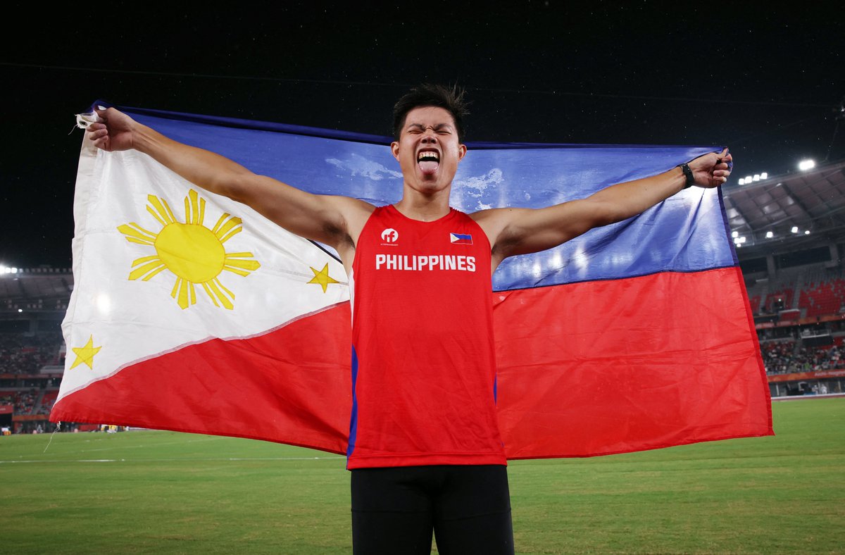PhilippineStar's tweet photo. NAMAMAYAGPAG! 🇵🇭☝️

EJ Obiena proudly holds a Philippine flag following back-to-back Asian Games gold medals in the men's pole vault finals on Tuesday. 

The two-time Olympian also set a new Asian Games record of 5.91 meters. 

Team Philippines now has its third gold medal at the 20th Asiad, courtesy of Obiena, following Carlos Yulo's double-gold performance in artistic gymnastics. (Wire photos/Reuters)