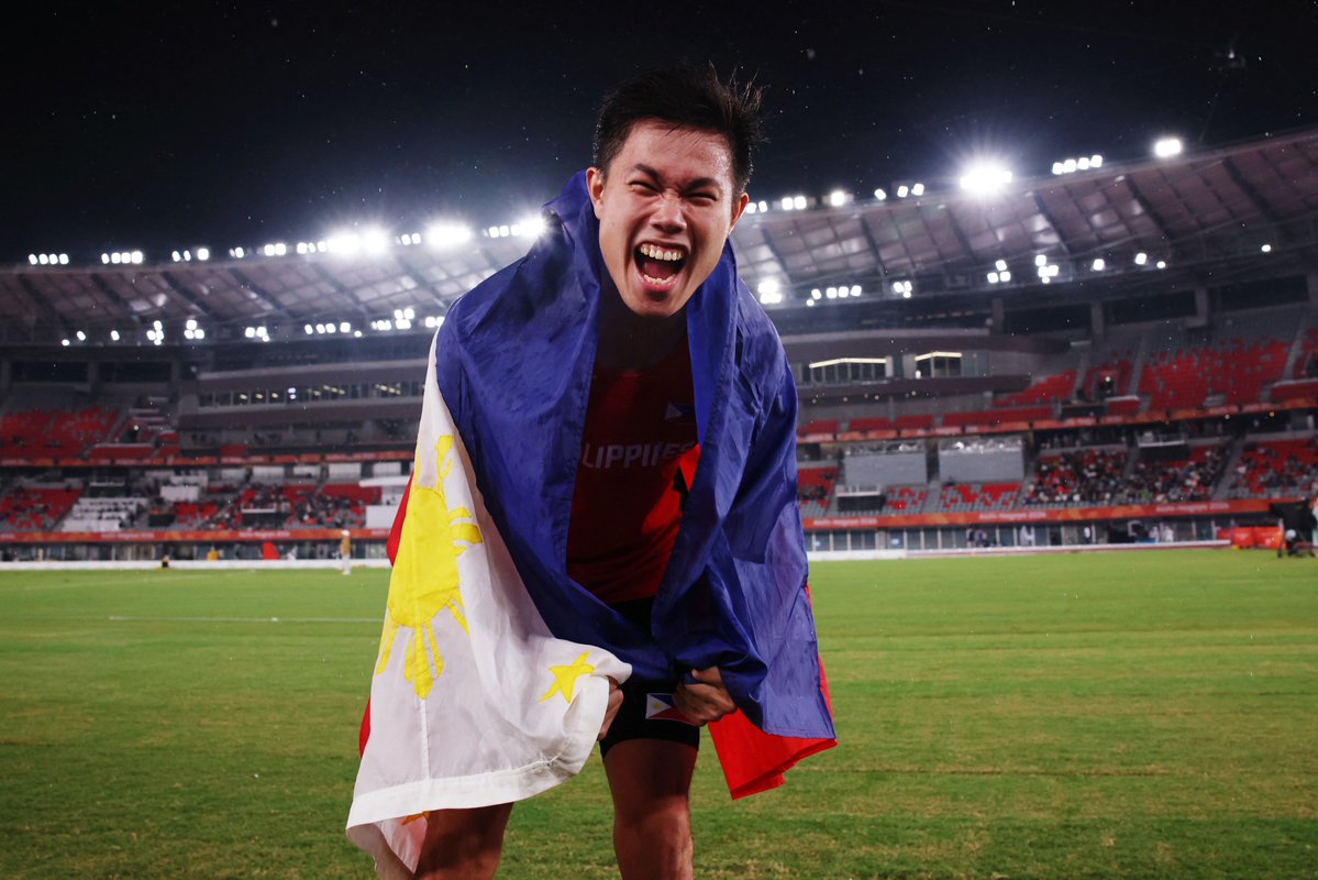 PhilippineStar's tweet photo. NAMAMAYAGPAG! 🇵🇭☝️

EJ Obiena proudly holds a Philippine flag following back-to-back Asian Games gold medals in the men's pole vault finals on Tuesday. 

The two-time Olympian also set a new Asian Games record of 5.91 meters. 

Team Philippines now has its third gold medal at the 20th Asiad, courtesy of Obiena, following Carlos Yulo's double-gold performance in artistic gymnastics. (Wire photos/Reuters)
