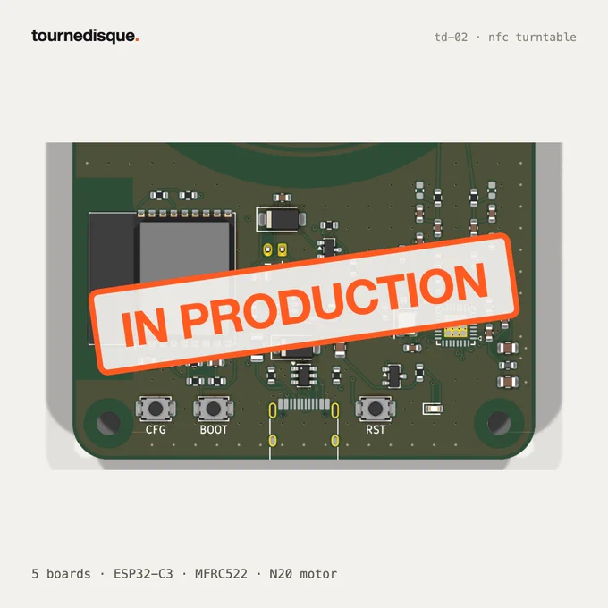 The front of the green PCB with an orange 'IN PRODUCTION' stamp across it.