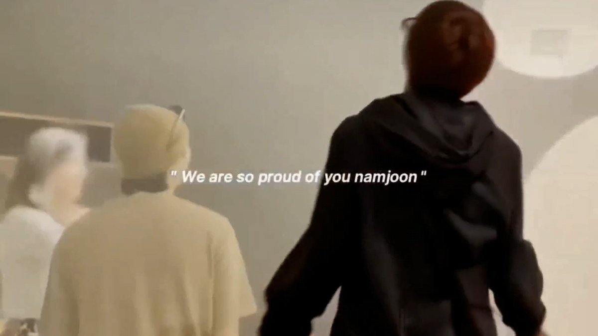 A photo of two people from behind, with overlaid text reading '" We are so proud of you namjoon "', likely referencing BTS member RM (Namjoon).