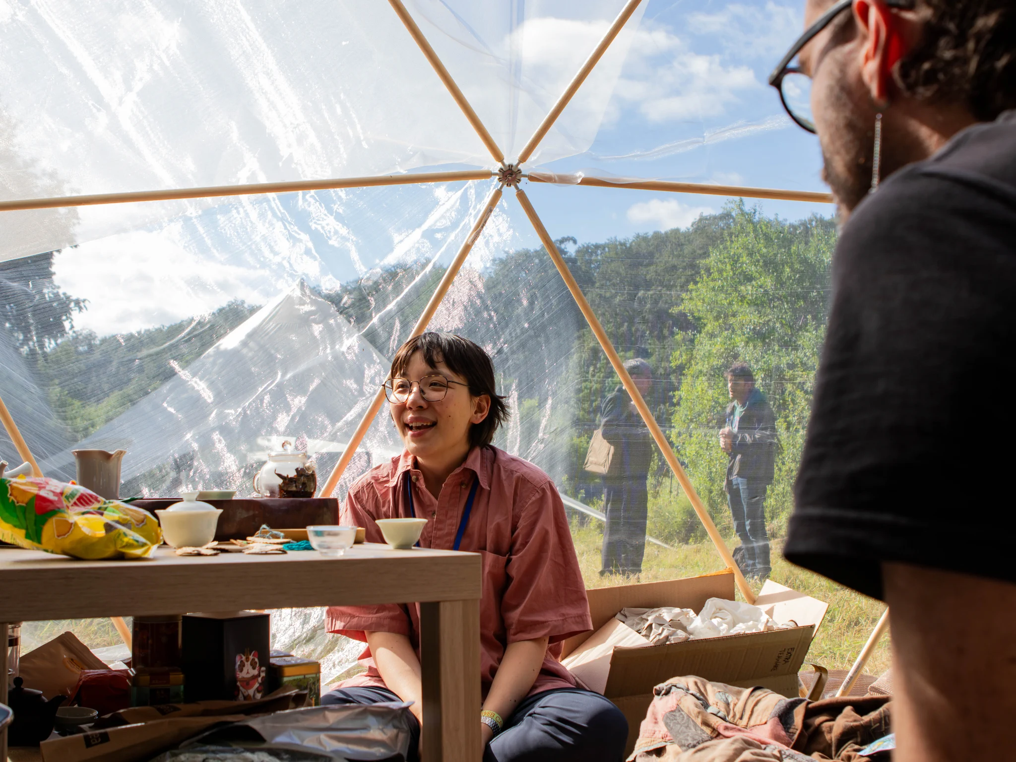 A participant sitting around a table during the Tea cerimony at DWeb Camp 2026